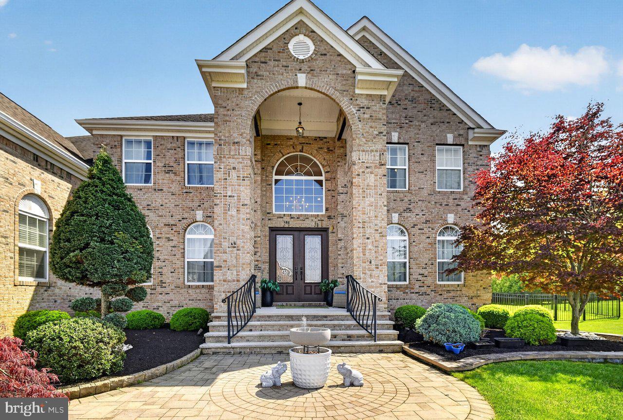 45 Emerald Road Robbinsville, NJ 08691 - Photo 2 of 57 Elegant brick facade with lush greenery.