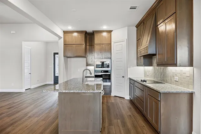 a kitchen with stainless steel appliances granite countertop a sink stove and refrigerator