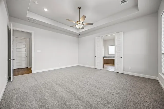 an empty room with fan and windows