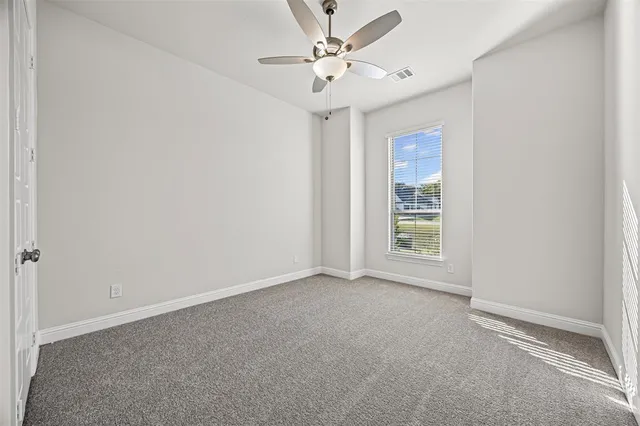 an empty room with fan and windows