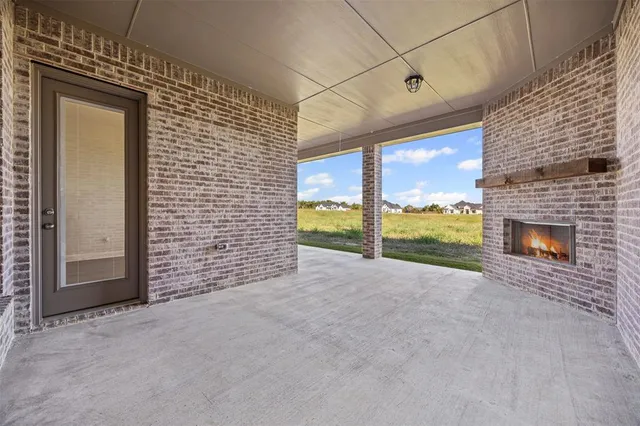 a view of an empty room with a fireplace and a window