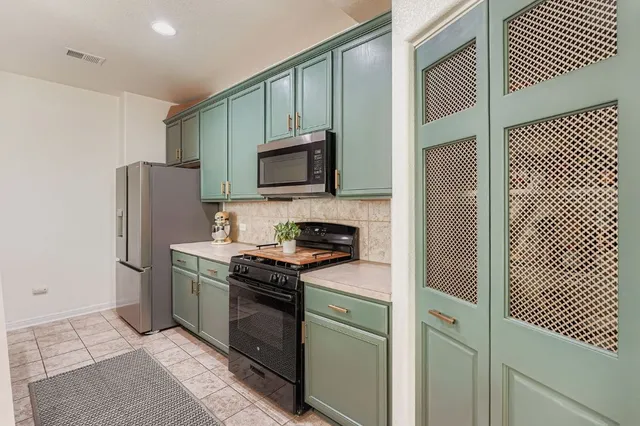 a kitchen with stainless steel appliances a stove microwave and refrigerator