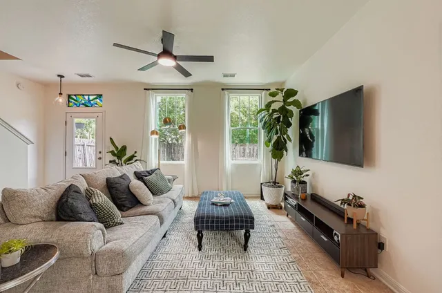 a living room with furniture a window and a flat screen tv
