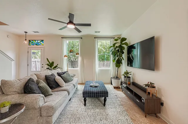 a living room with furniture a window and a flat screen tv