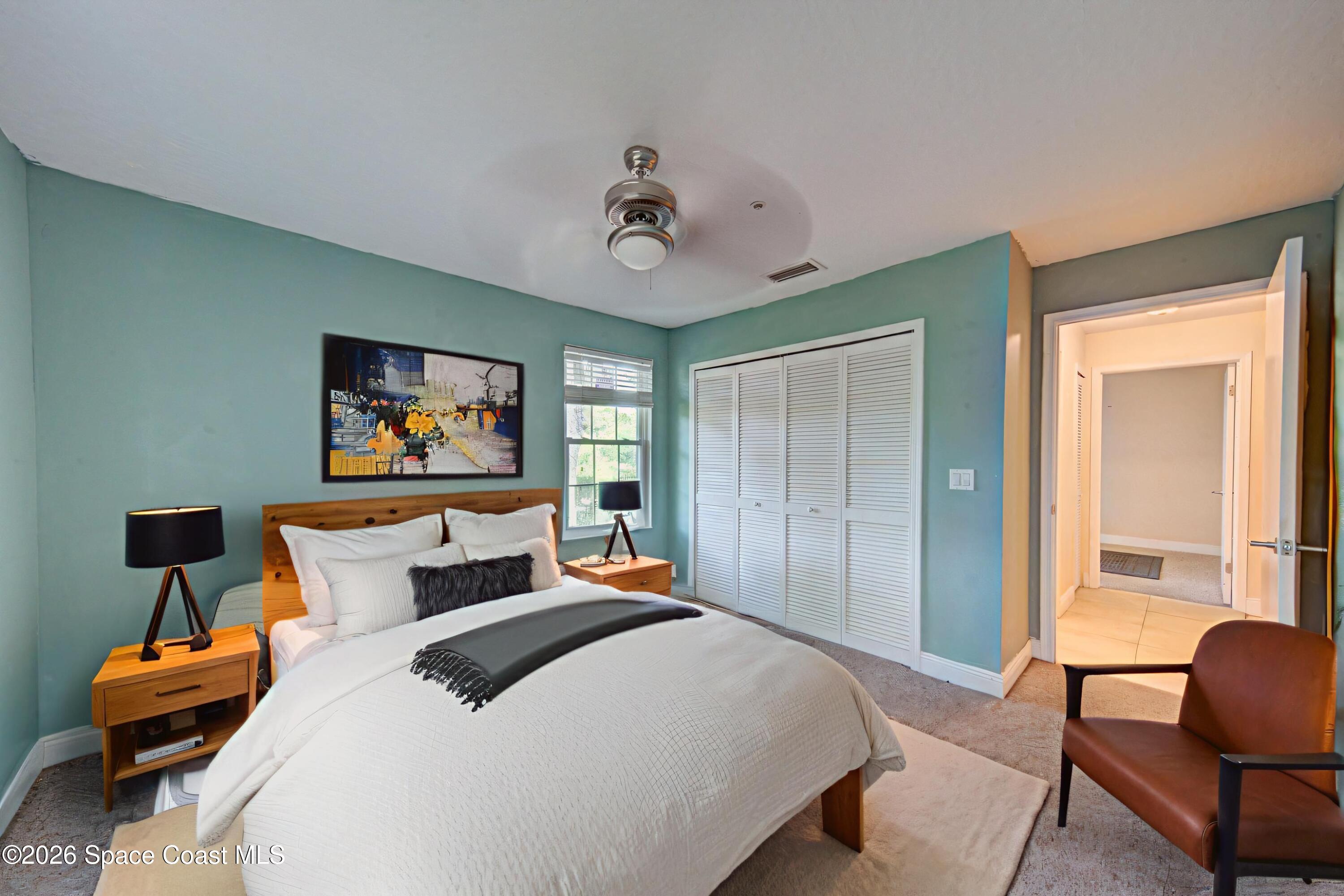 7667 North Wickham Road, Unit 1416 Melbourne, FL 32940 - Photo 23 of 41 a bedroom with a bed and a chandelier