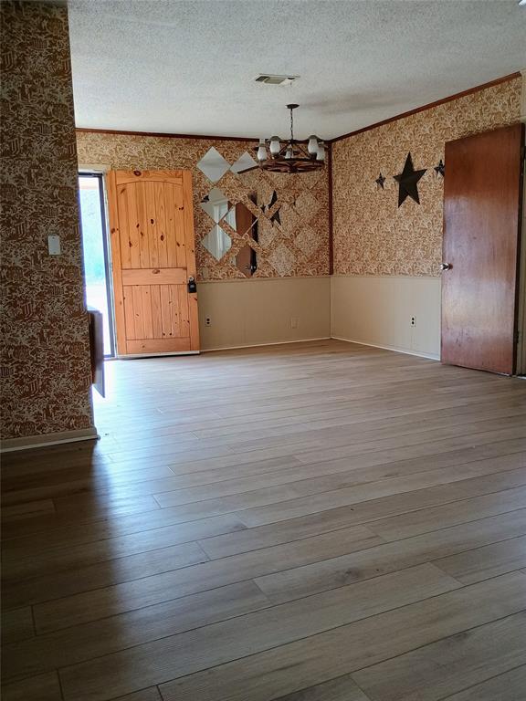 1303 East Boynton Hamilton, TX 76531 - Photo 18 of 21 a view of a big room with wooden floor and cabinet