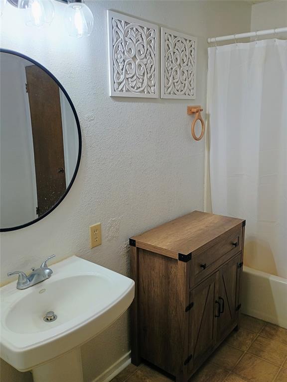 1303 East Boynton Hamilton, TX 76531 - Photo 19 of 21 a bathroom with a sink and a mirror