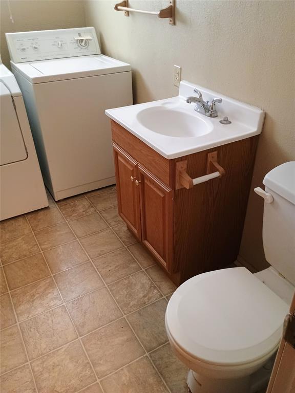 1303 East Boynton Hamilton, TX 76531 - Photo 20 of 21 a bathroom with a sink a toilet and a mirror