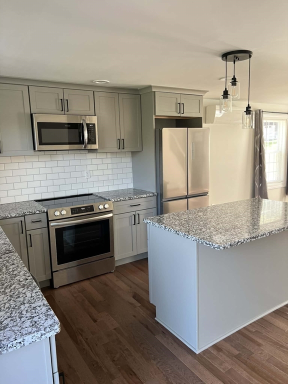 313-315 Walnut Hill Road Orange, MA 01364 - Photo 6 of 19 a kitchen with stainless steel appliances granite countertop a stove a microwave and a refrigerator