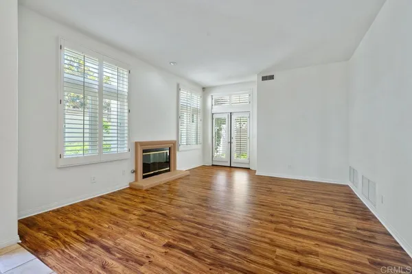 a view of a room with a window and wooden floor
