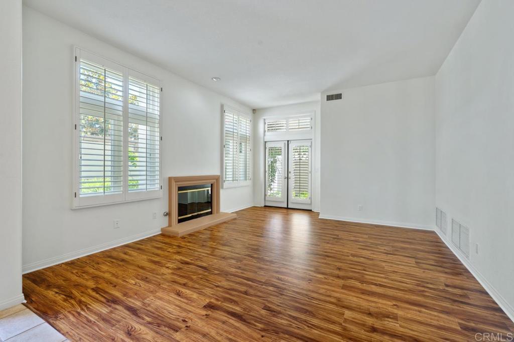 5402 Renaissance Avenue San Diego, CA 92122 - Photo 11 of 73 a view of empty room with wooden floor and fireplace