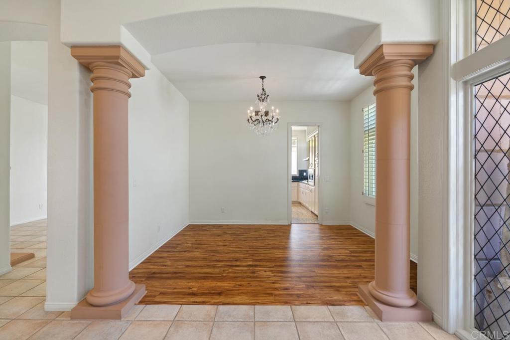 5402 Renaissance Avenue San Diego, CA 92122 - Photo 16 of 73 a view of a hallway with wooden floor and a chandelier