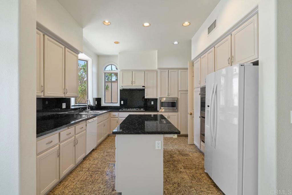 5402 Renaissance Avenue San Diego, CA 92122 - Photo 24 of 73 a kitchen with granite countertop a refrigerator and a sink