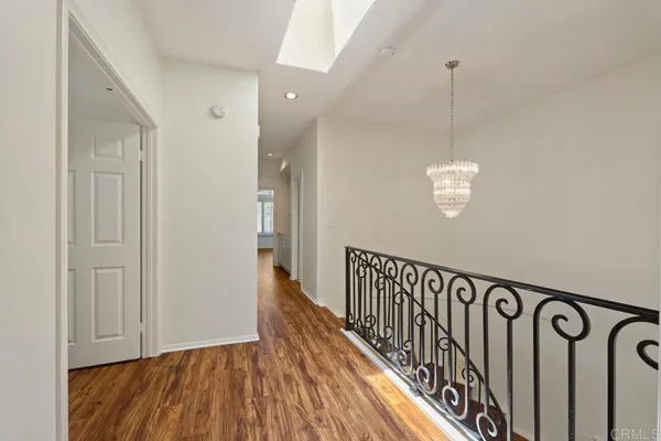 a view of an empty room with wooden floor and closet