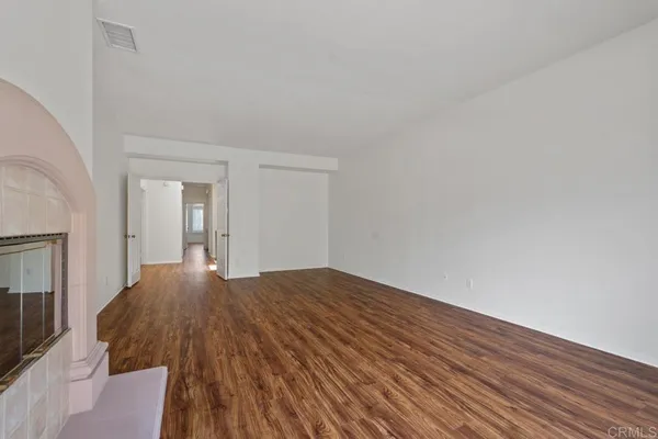 a view of a kitchen with white cabinets and wooden floor