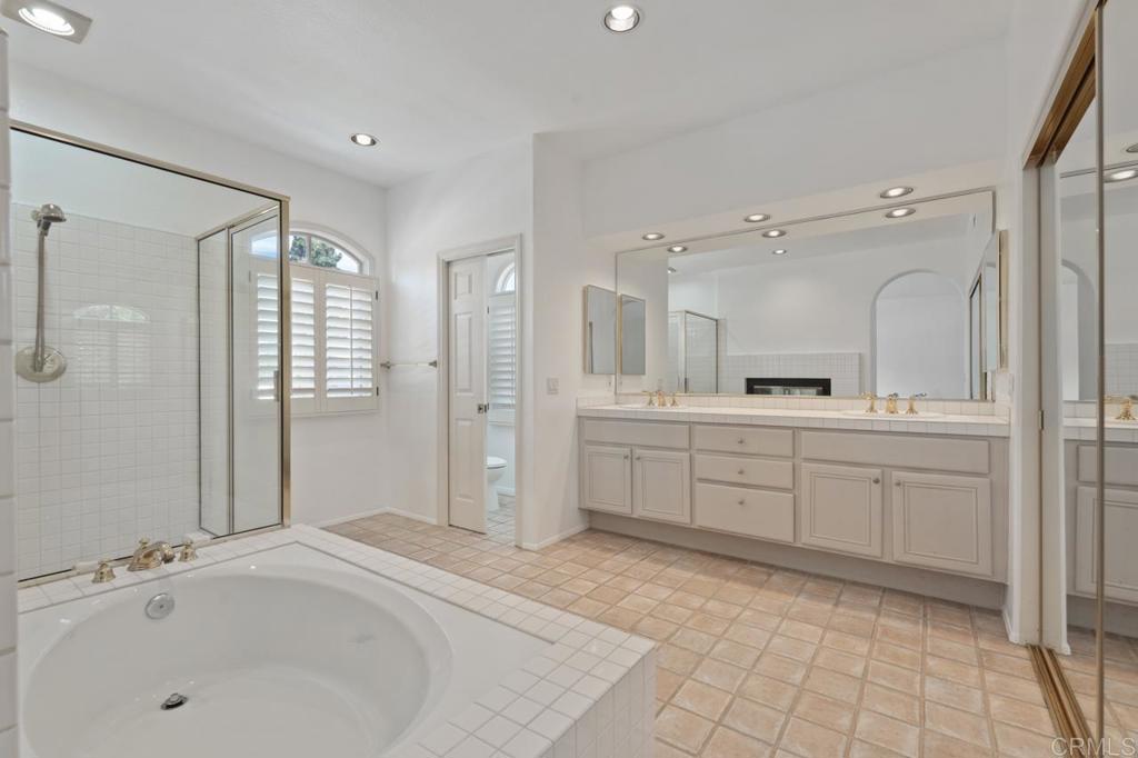 5402 Renaissance Avenue San Diego, CA 92122 - Photo 39 of 73 a spacious bathroom with a granite countertop sink mirror and a