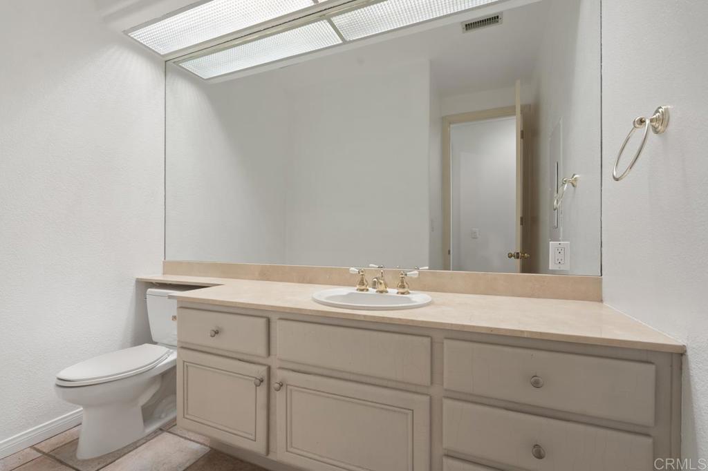5402 Renaissance Avenue San Diego, CA 92122 - Photo 55 of 73 a bathroom with a granite countertop sink and a toilet