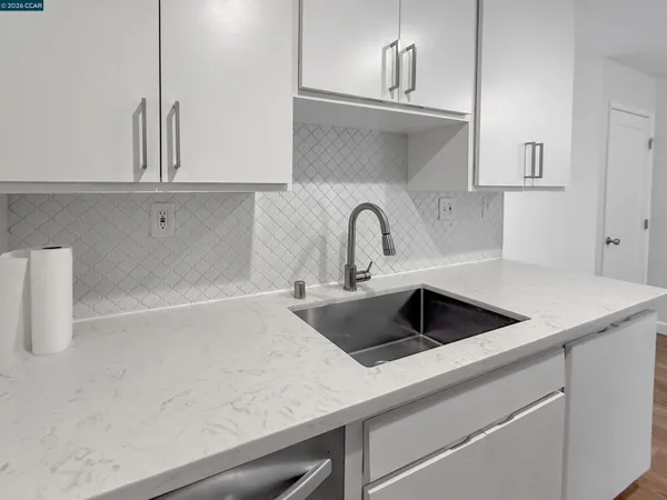 a kitchen with sink a refrigerator and cabinets