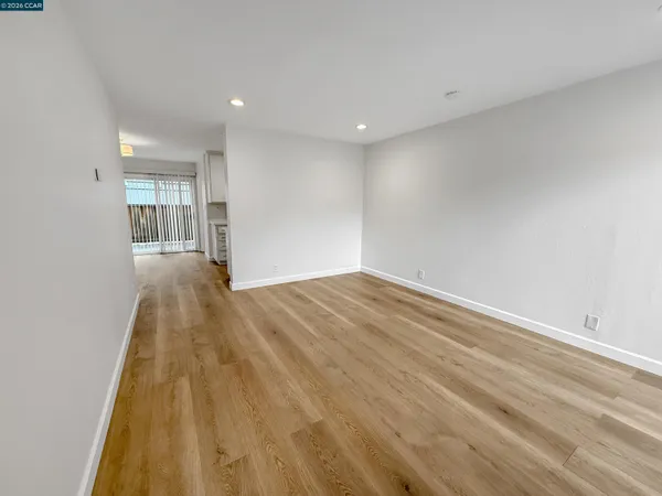 a view of empty room with wooden floor