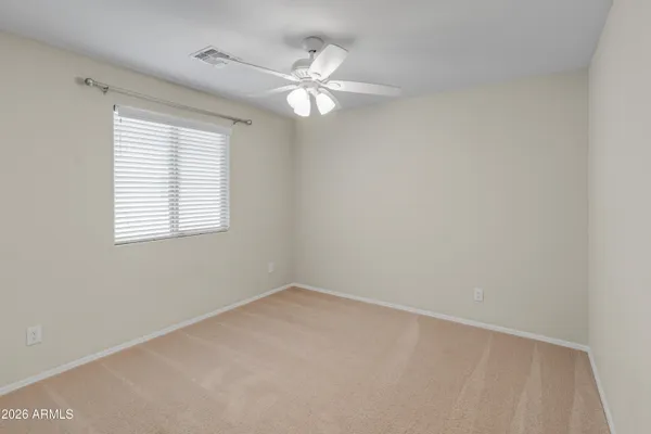an empty room with closet and a ceiling fan