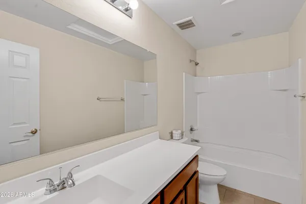 a bathroom with a tub shower sink and mirror