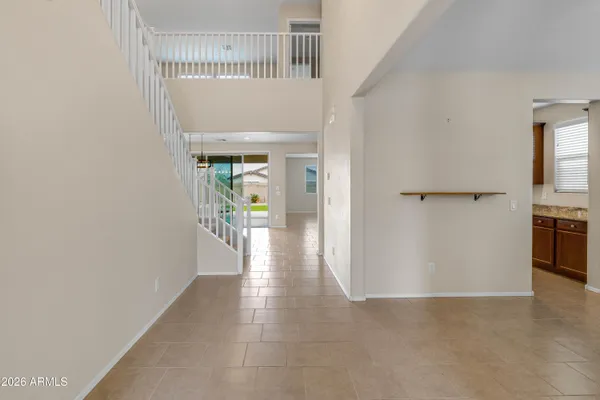 a view of a hallway with wooden floor and a kitchen