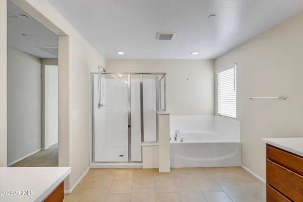 a bathroom with a tub sink and mirror