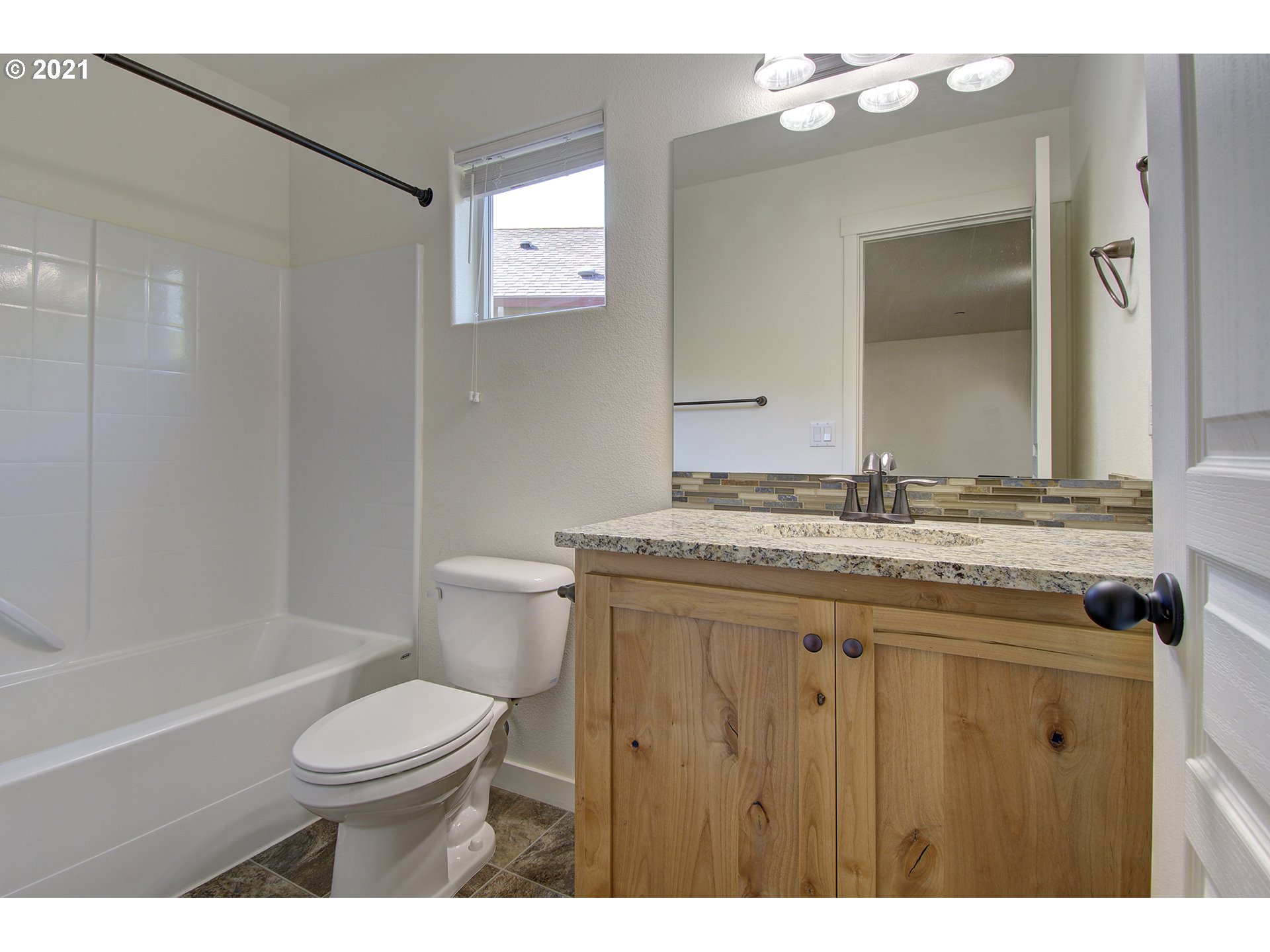 162 North 41st Place Ridgefield, WA 98642 - Photo 27 of 29 a bathroom with a granite countertop toilet a sink and a mirror