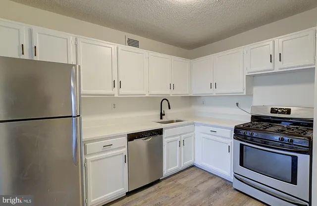 a kitchen with white cabinets and white appliances