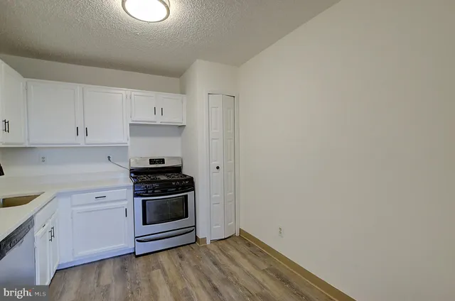 a kitchen with a stove oven and white cabinets