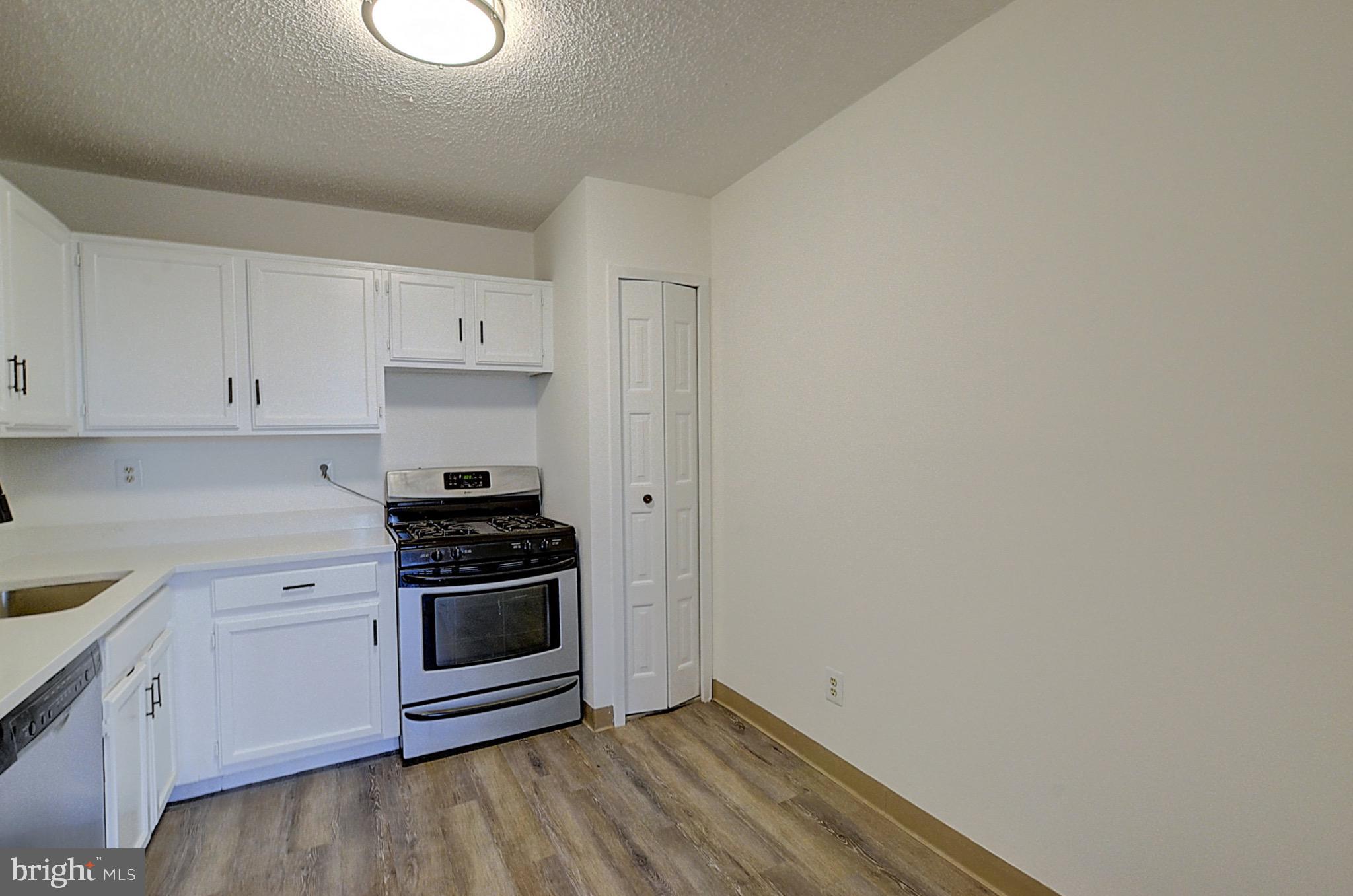 5225 Pooks Hill Road, Unit 324N Bethesda, MD 20814 - Photo 10 of 34 a kitchen with a stove oven and white cabinets