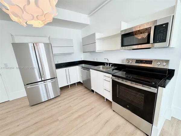 a kitchen with stainless steel appliances a stove microwave and refrigerator