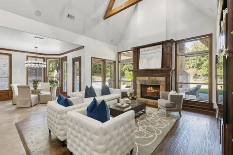 a living room with furniture large window and wooden floor
