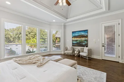 a bedroom with a bed and large windows