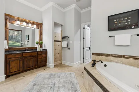 a spacious bathroom with a tub sink and mirror
