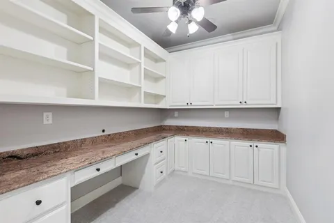 a kitchen with granite countertop white cabinets and stainless steel appliances