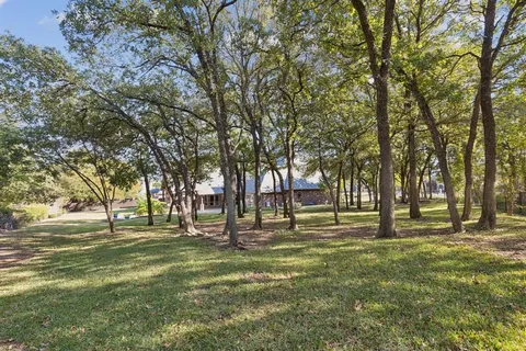 an aerial view of a house with a yard and lake