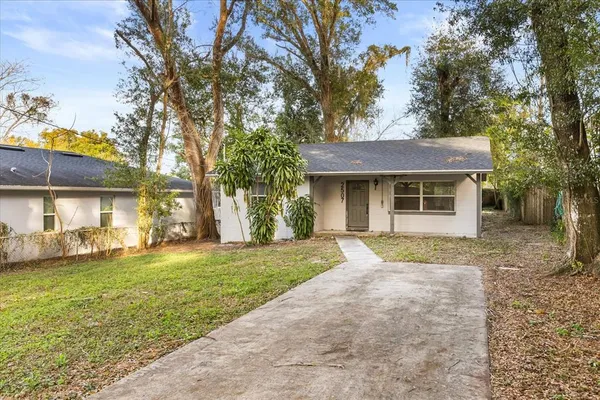 a front view of a house with a yard and trees