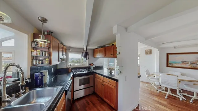 a kitchen with stainless steel appliances granite countertop a sink stove and cabinets