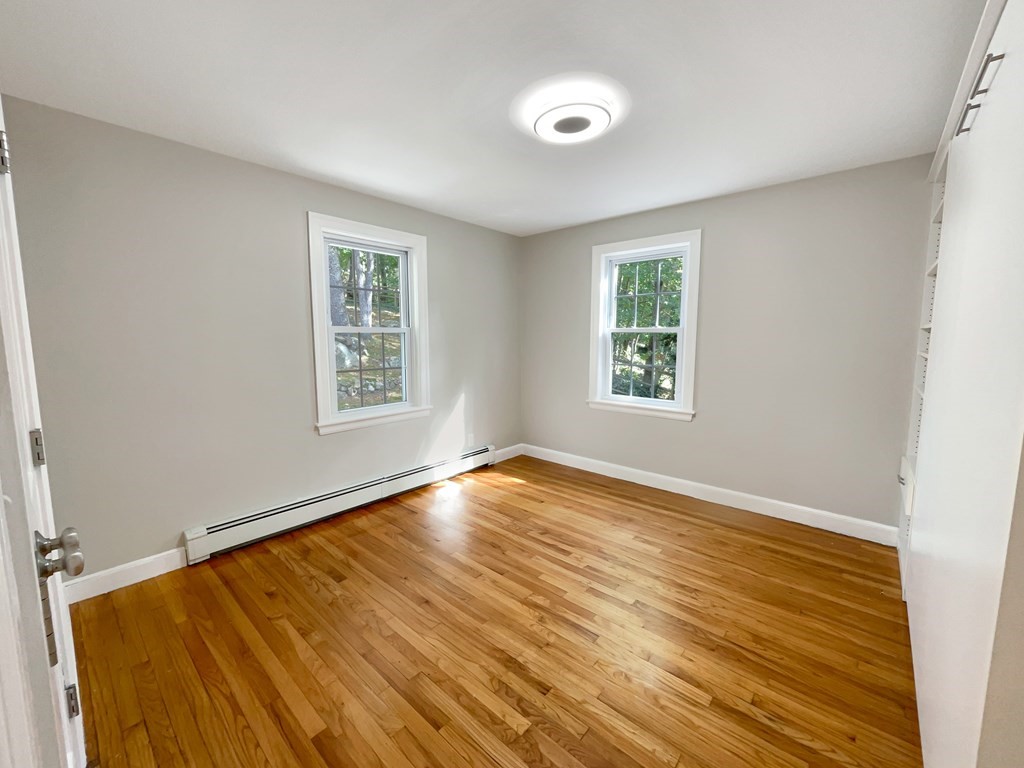 22 Watertown Street Lexington, MA 02421 - Photo 5 of 34 a view of an empty room with wooden floor and a window
