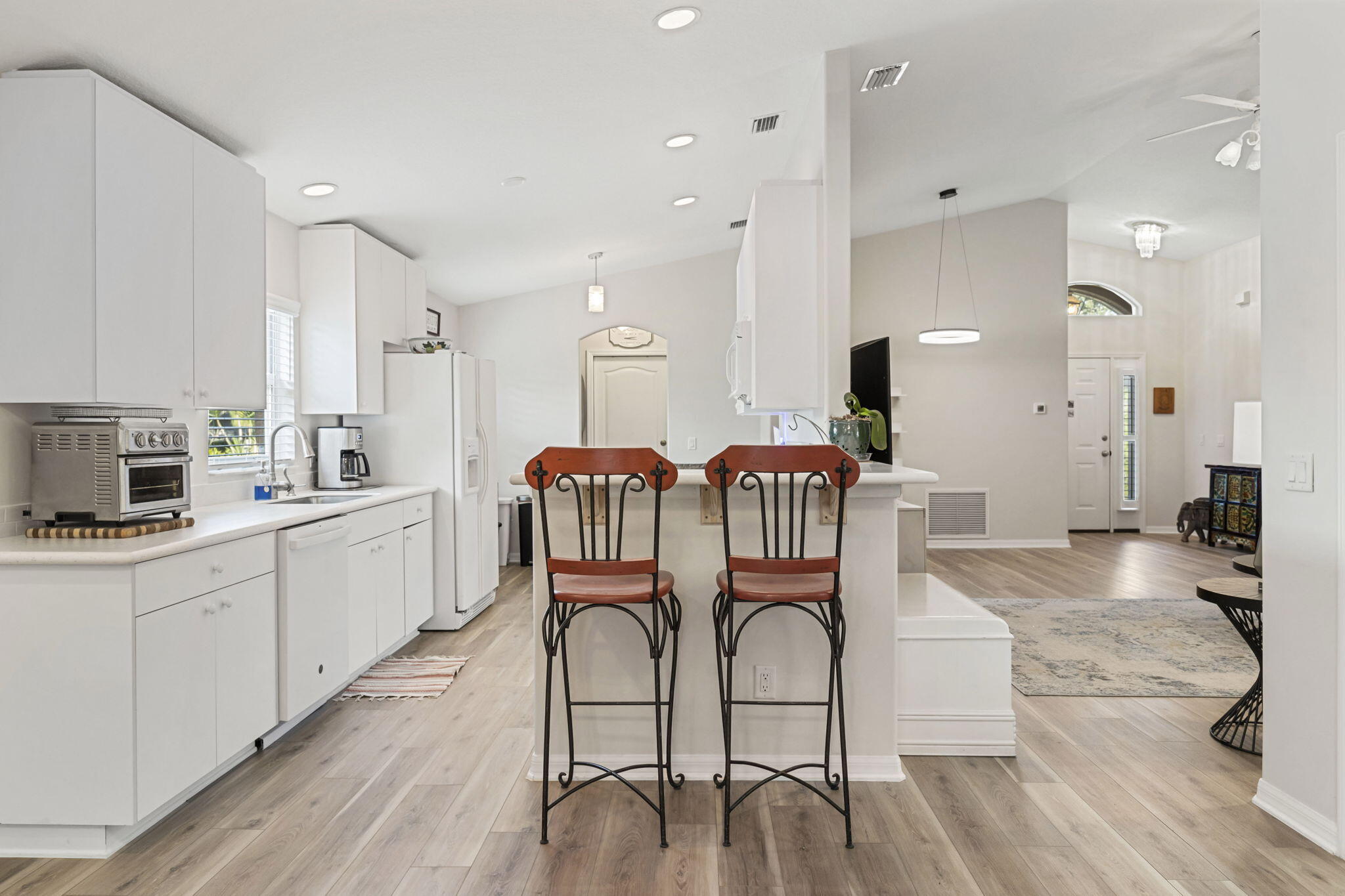 2140 Spring Creek Circle Palm Bay, FL 32905 - Photo 7 of 32 a open kitchen with stainless steel appliances kitchen island granite countertop a table chairs and a sink