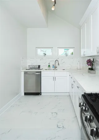 a kitchen with white cabinets and a white counter