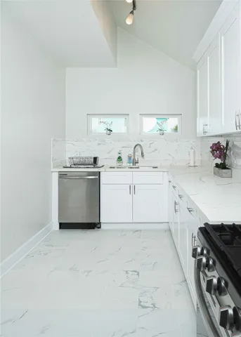 a kitchen with white cabinets and a white counter