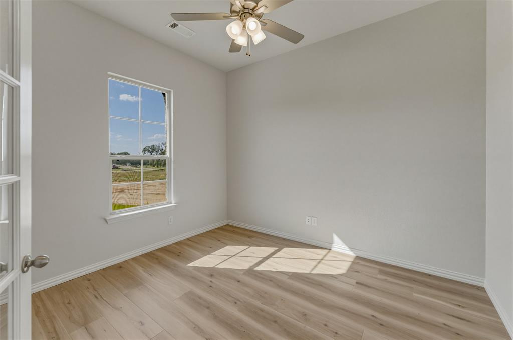 605 Tay Tay Way Springtown, TX 76082 - Photo 10 of 31 Room featuring wood-finish flooring, a ceiling fan with integrated lighting, and a window with a wide sill