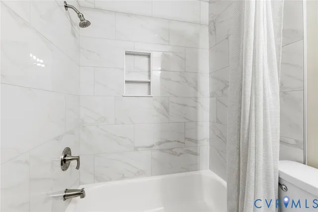 a bathroom with a granite countertop toilet sink and mirror