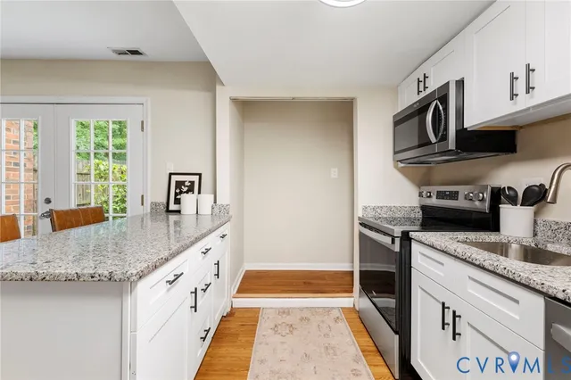 a kitchen with granite countertop a sink and a stove top oven