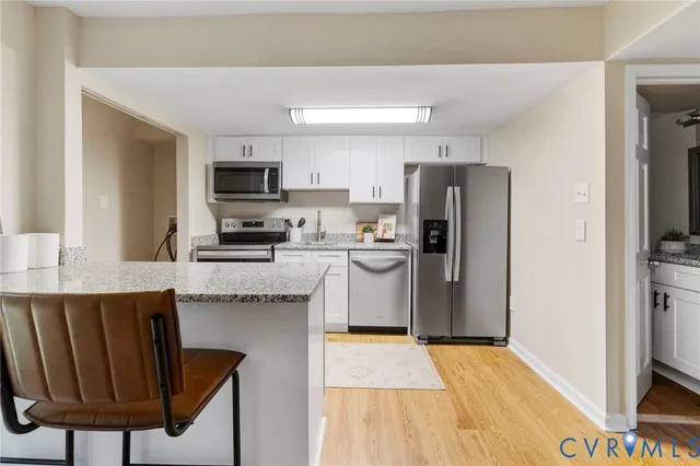 a kitchen with stainless steel appliances granite countertop a refrigerator and a stove top oven