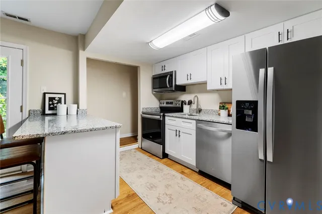 a kitchen with stainless steel appliances granite countertop a refrigerator stove microwave and sink