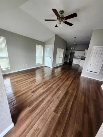 a view of empty room with wooden floor