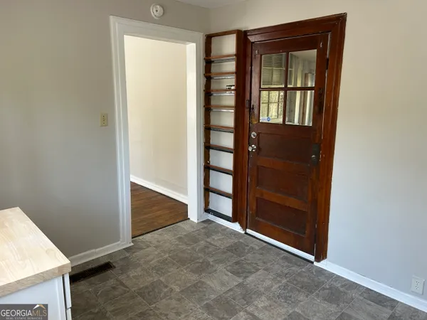 an empty room with window and cabinet